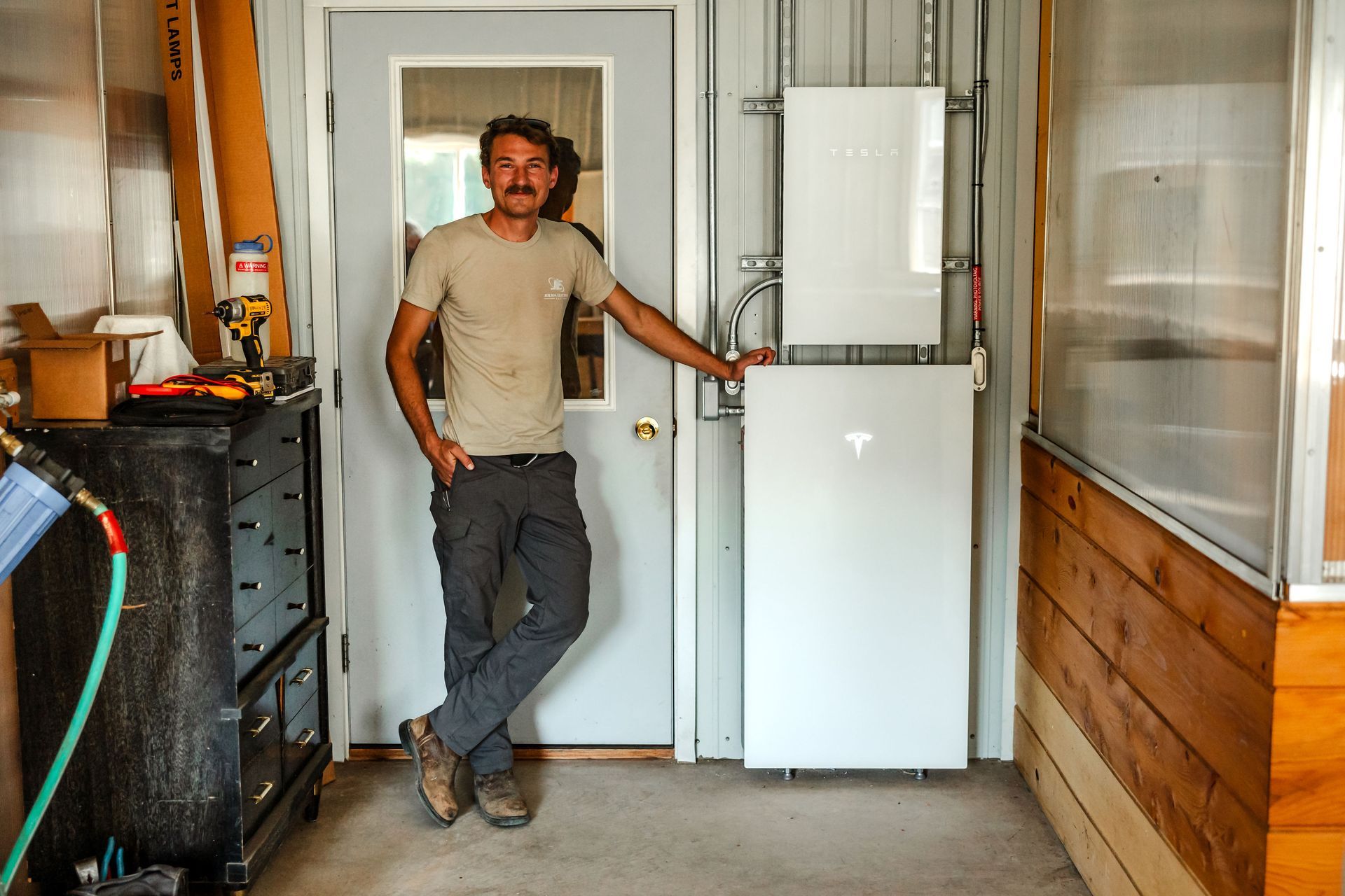 Man standing in a doorway beside a white appliance in a narrow indoor corridor Man standing in a doorway beside a white appliance in a narrow indoor corridor