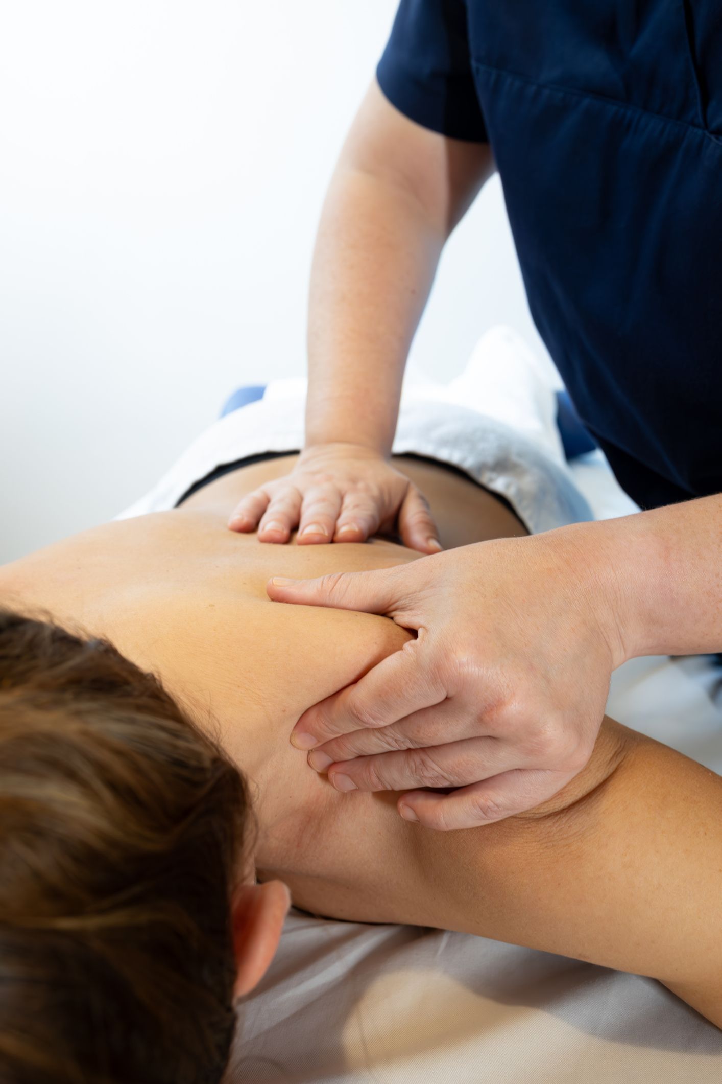 A therapist giving a chest adjustment to a man lying on a massage table.