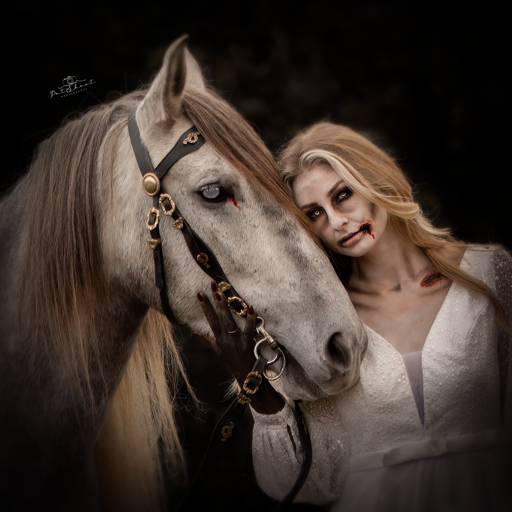 Vrouw in witte jurk met zombie-make-up en grijs paard.
