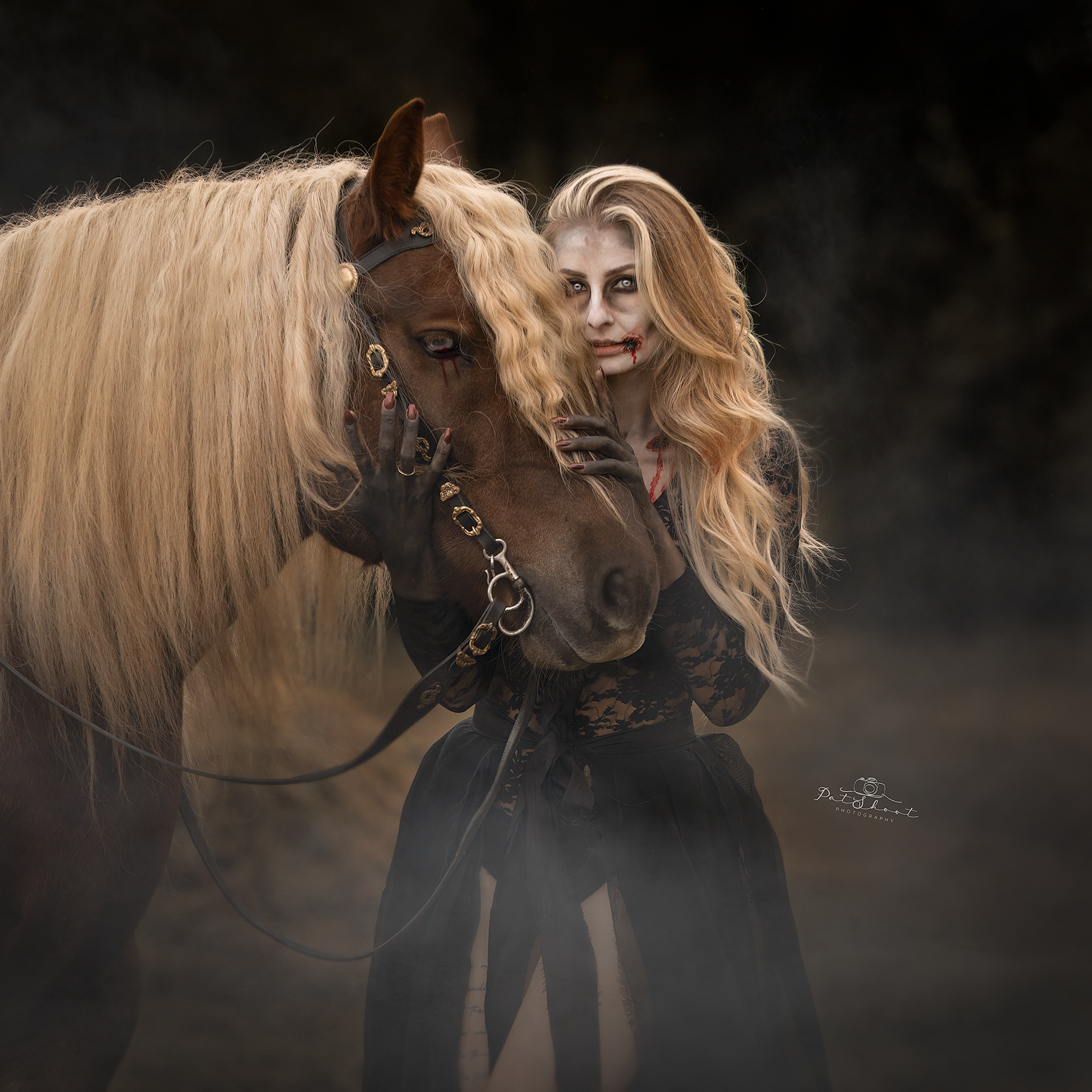 Een vrouw met zombie-make-up, in een zwarte jurk, omhelst een bruin paard met een lange blonde manen.