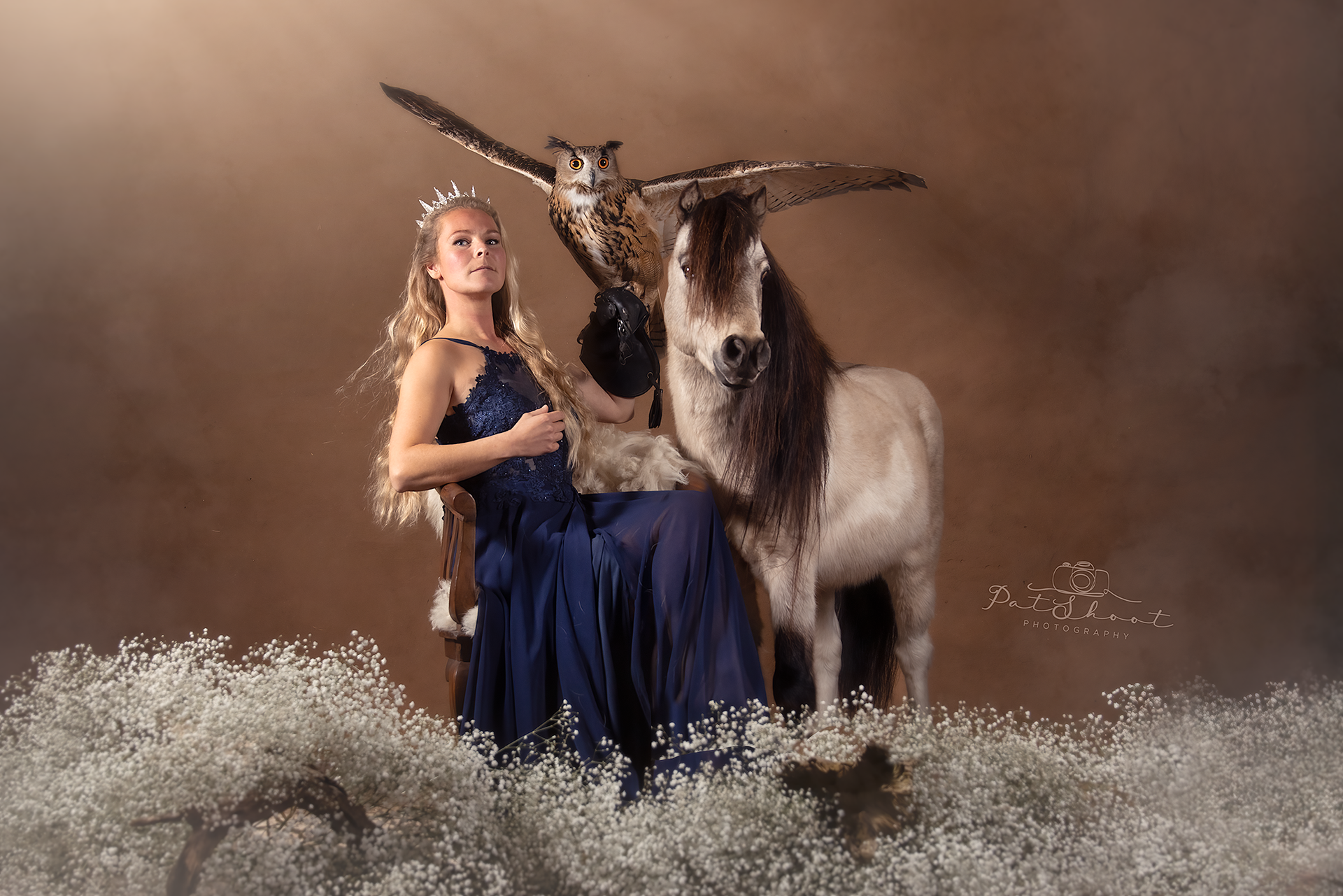 minipaardje met mooi model in sprookjes jurk en indrukwekkende oehoe
