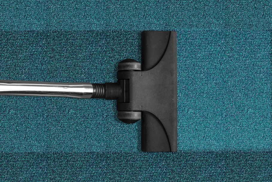 Vacuum cleaner head on teal carpet, shown from above
