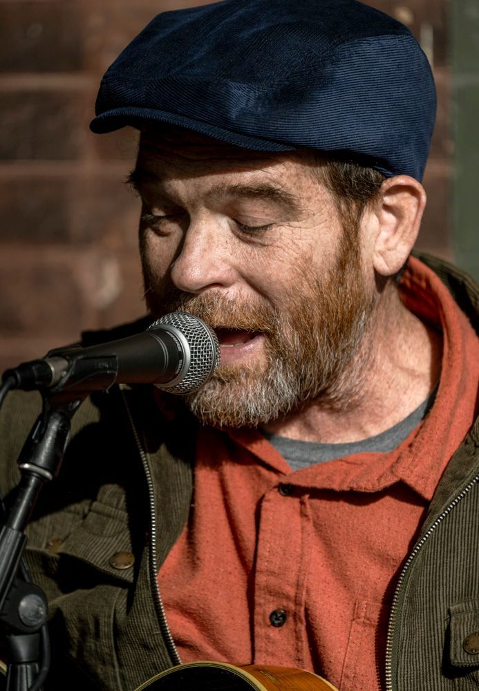Tommy Halloran, jazz guitarist, singer, St. Louis native, a man singing into a microphone with his eyes closed