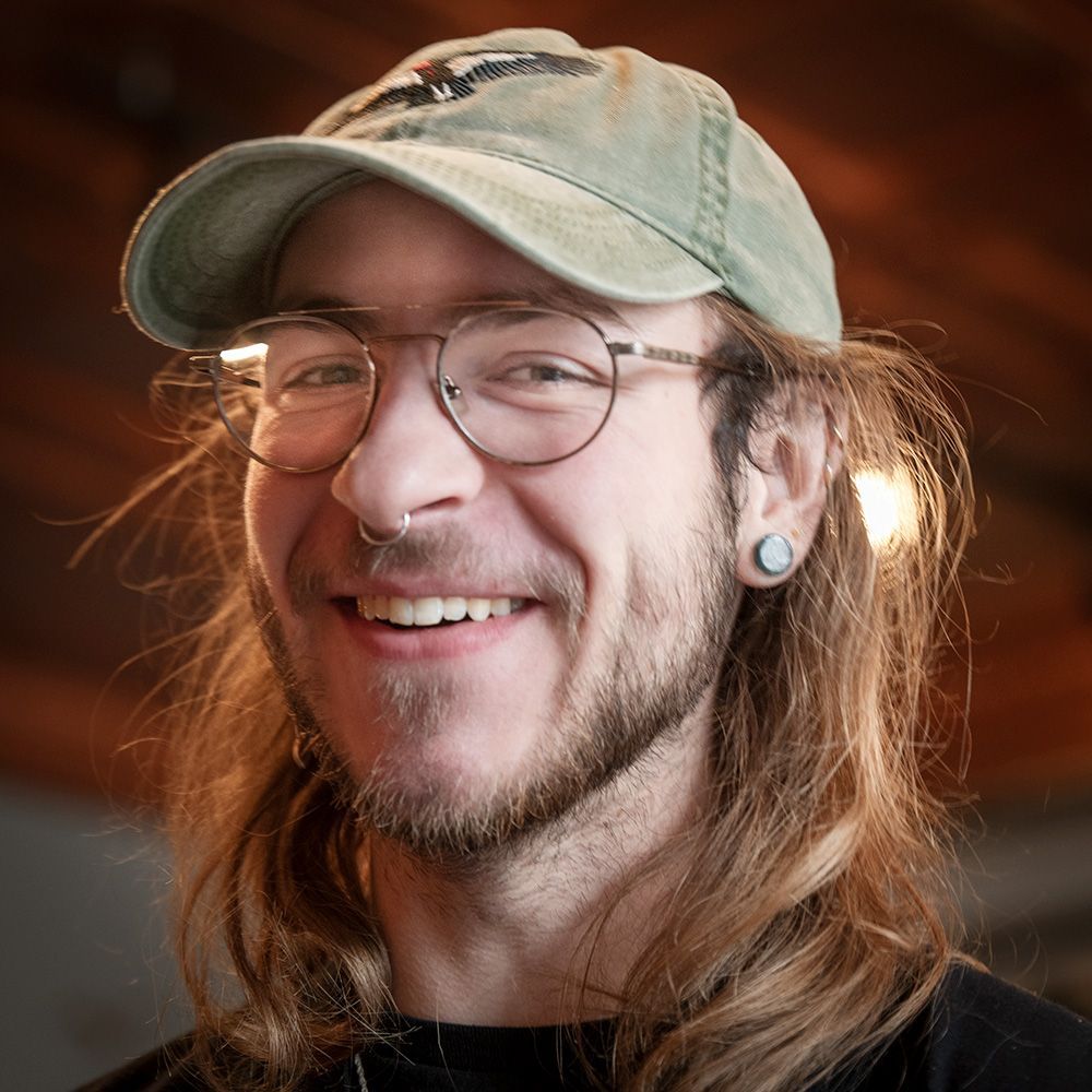 a man with long hair wearing glasses and a hat is smiling, Raven, server at Grand Pied on Morganford, St. Louis, MO