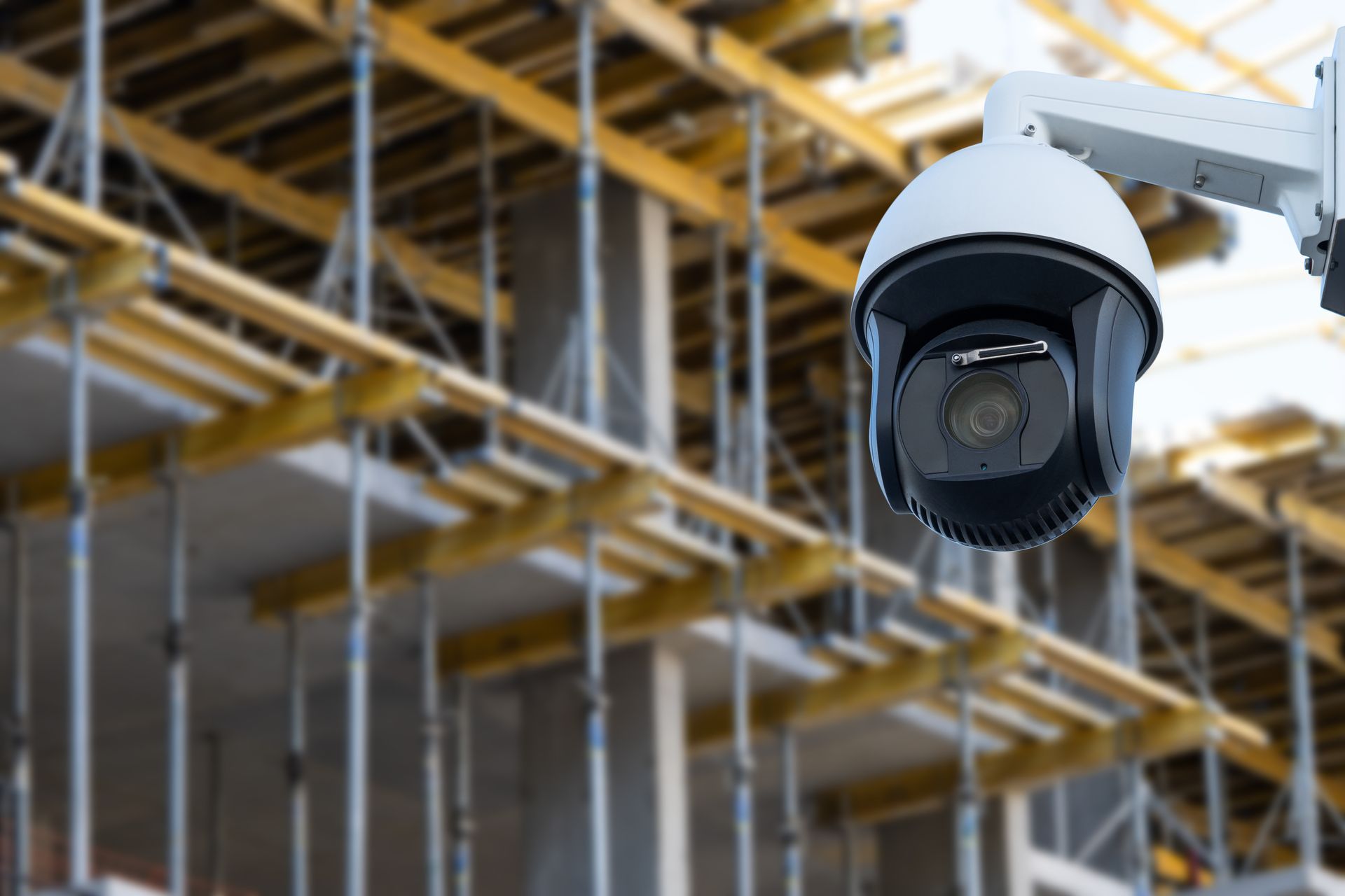 Une caméra de sécurité est suspendue au plafond d'un bâtiment en construction.