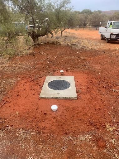 A White Truck Is Parked In A Dirt Field Next To A Concrete Slab — Araluen Plumbing In Braitling, NT