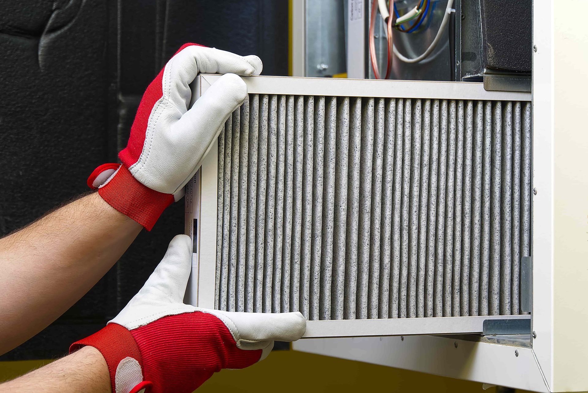 A person wearing red and white gloves is holding a filter.