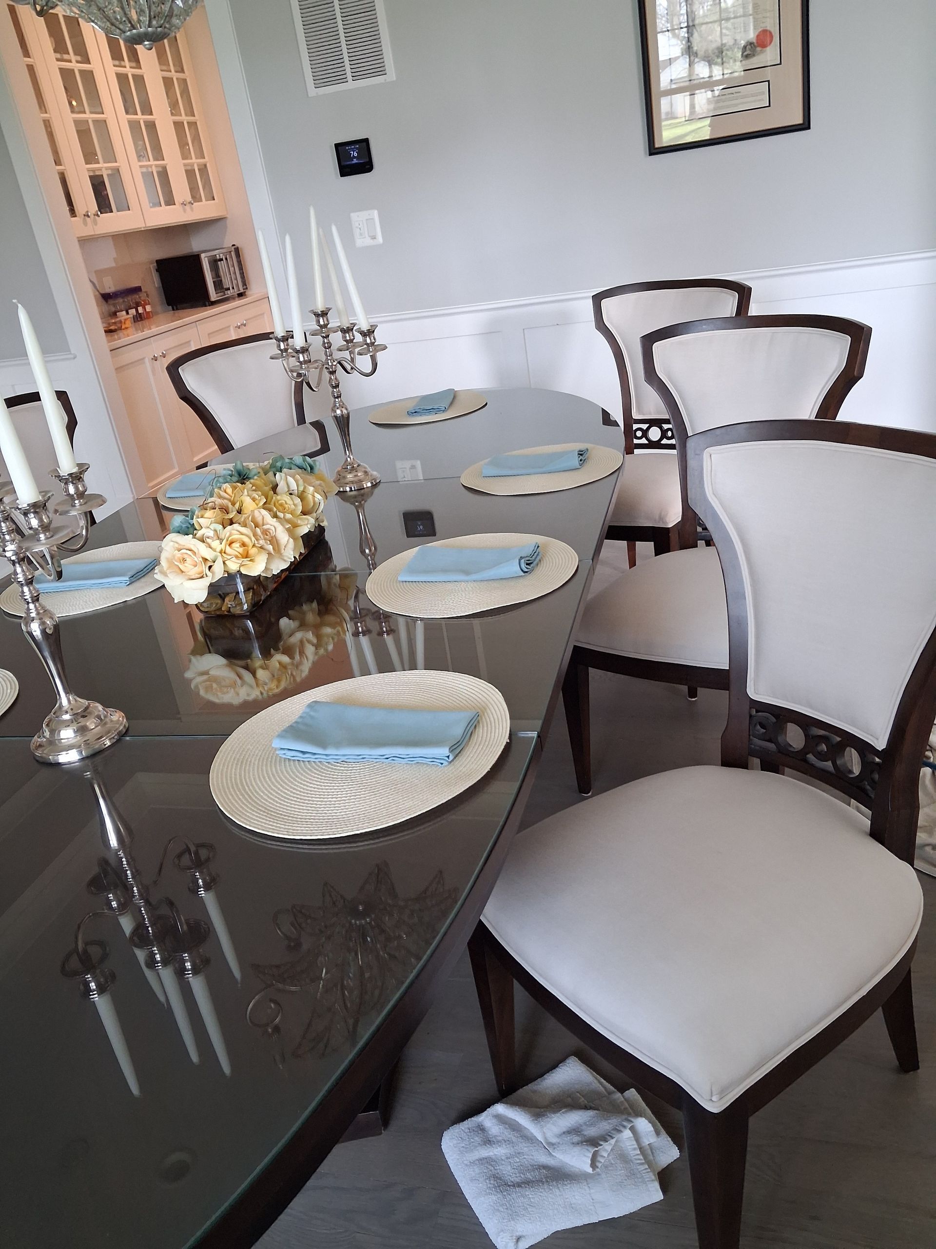 Dining table set with plates and blue napkins in a bright modern dining room