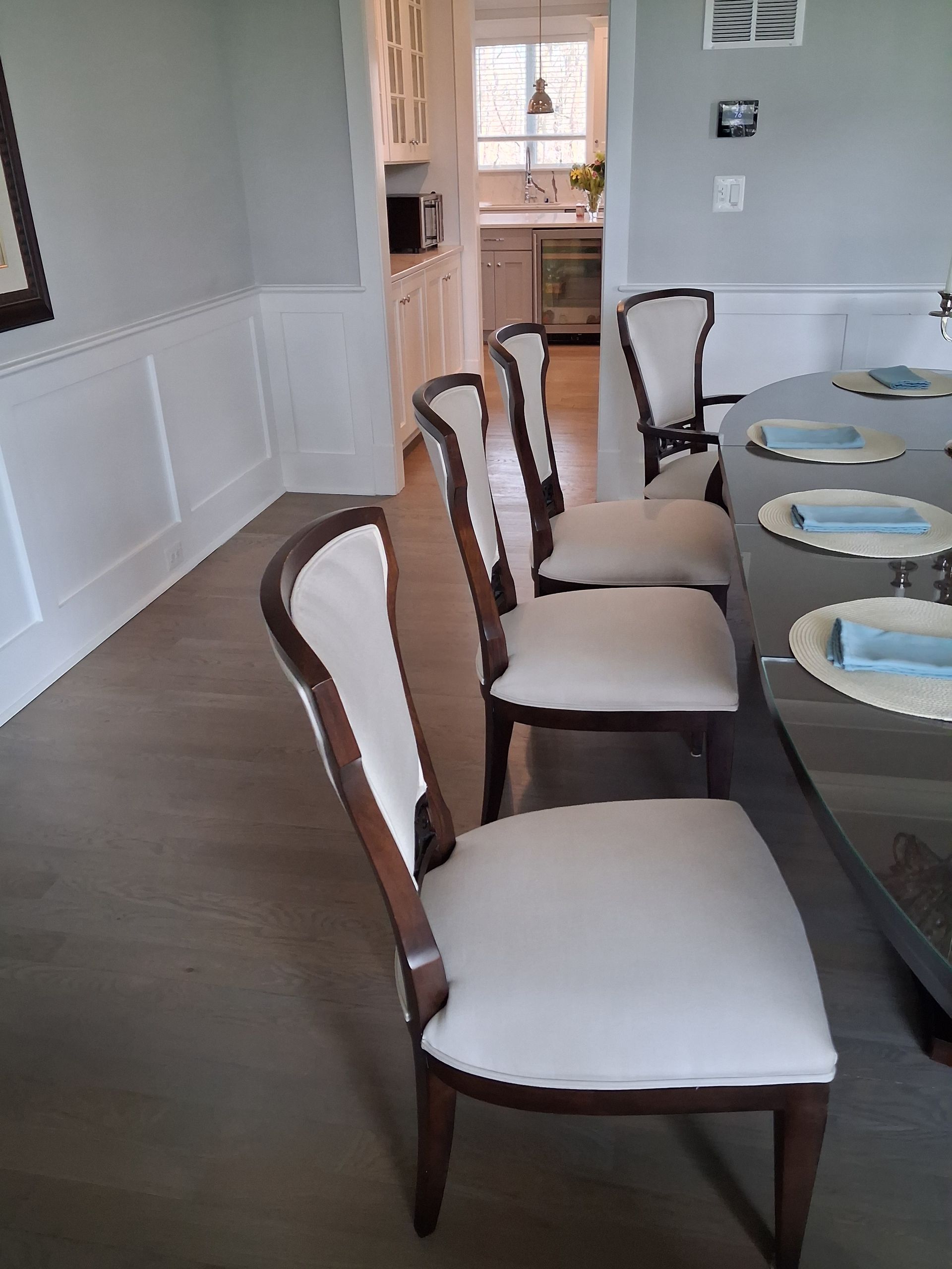 Dining room with a long table set for a meal and four upholstered chairs along the side.