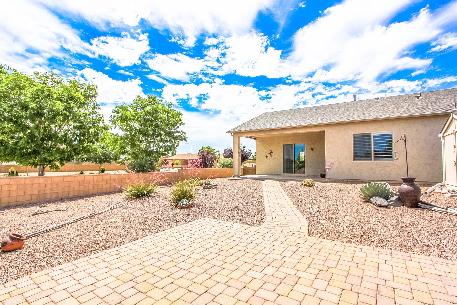 A house with a brick walkway leading to it is for sale.