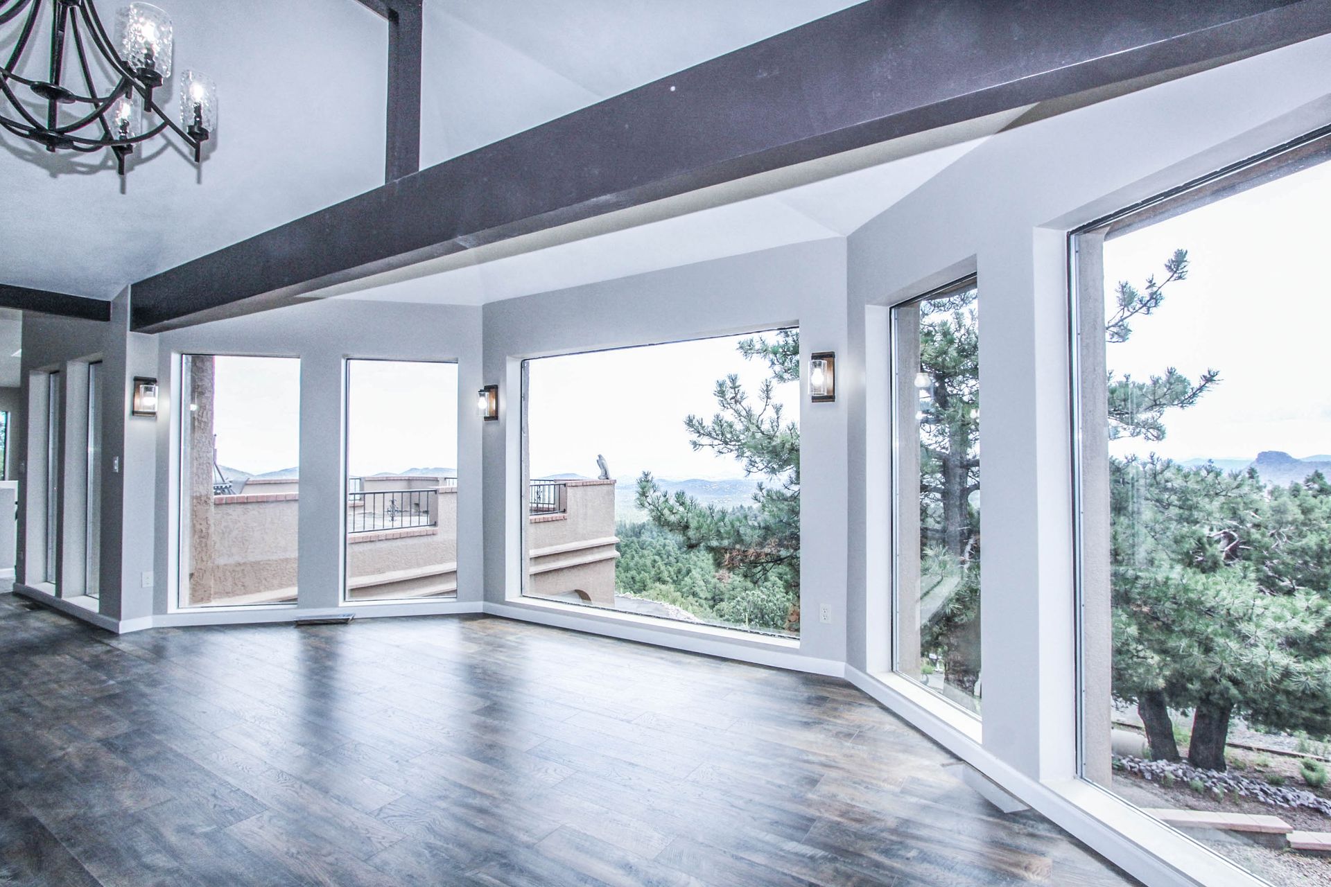 An empty room with a lot of windows and a chandelier