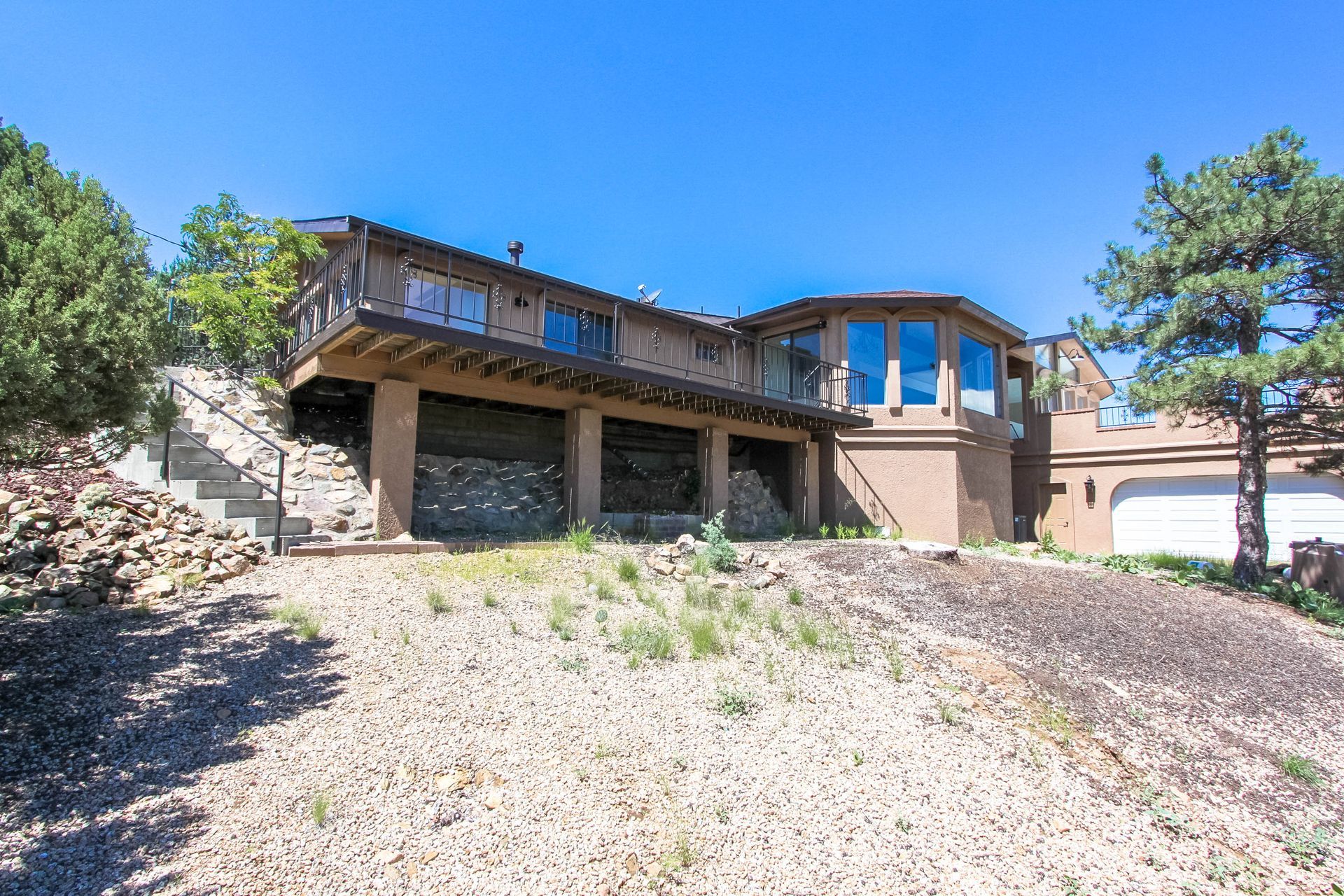 A large house is sitting on top of a dirt hill.