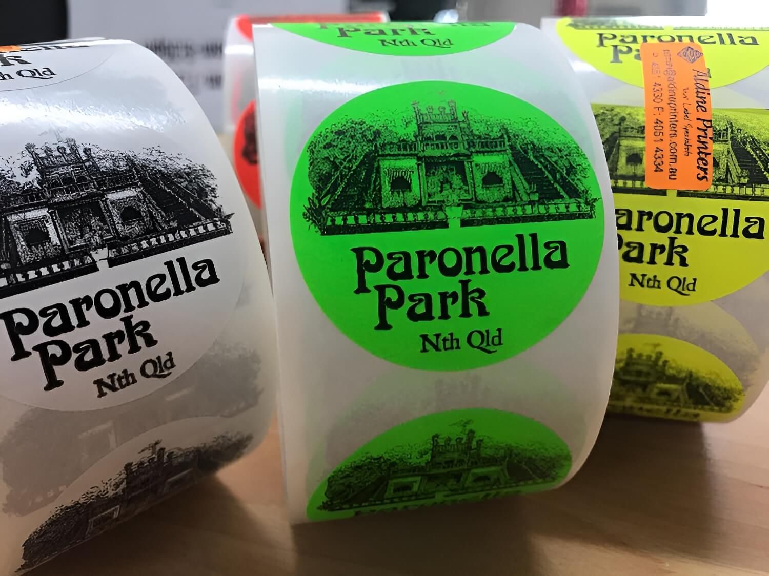 Three rolls of paronella park stickers on a table — Aldine Printers in Bungalow, QLD
