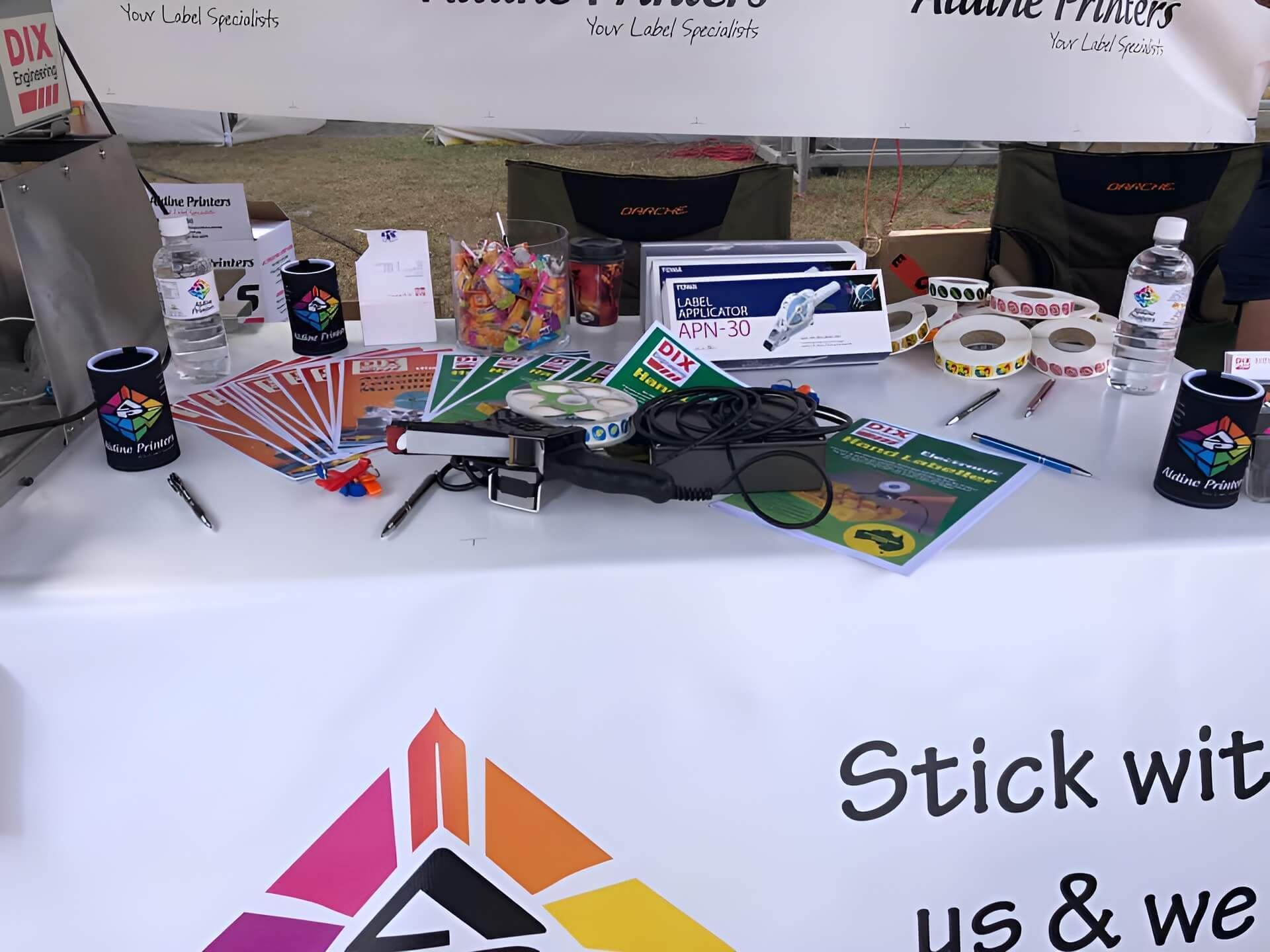 A Table With a Sign That Says Stick With Us — Aldine Printers in Bungalow, QLD