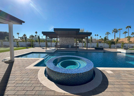Paver deck surrounding a renovated pool and spa