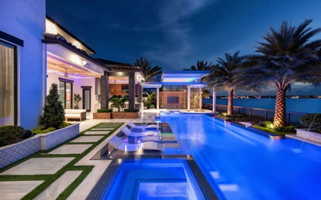 LED-lit pool and outdoor living area glowing at night