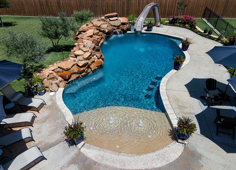 Custom pool slide built into a backyard pool