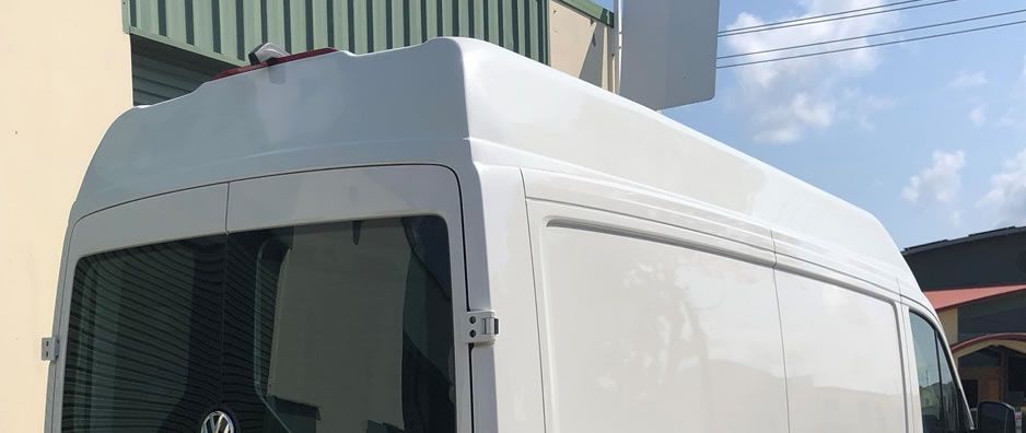 A white van is parked in front of a building.