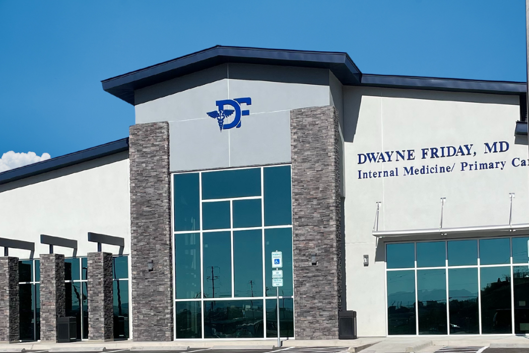A large building with a lot of windows and a blue sign on the top of it.