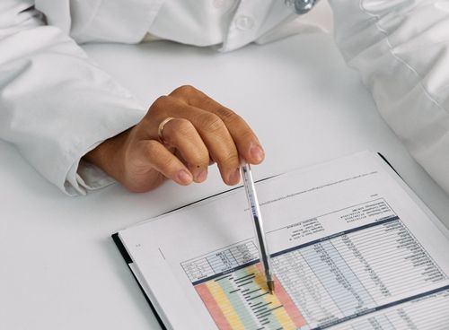 A person is holding a pen over a piece of paper.