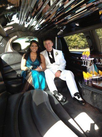 A man and a woman are sitting in the back of a limousine