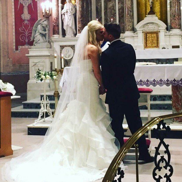 A bride and groom kissing in front of an altar