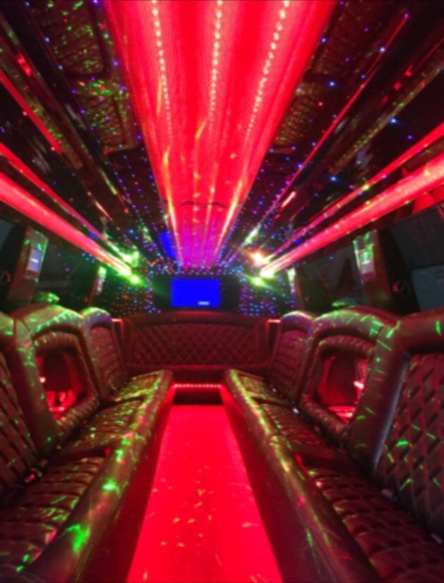 The inside of a limousine with red lights on the ceiling