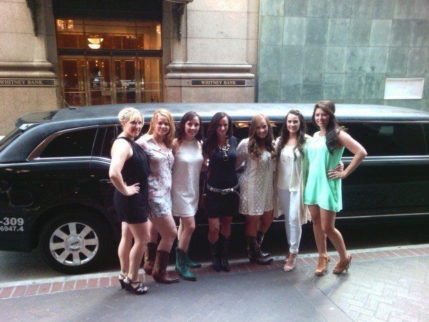 A group of women standing in front of a limousine that says 309 on the side
