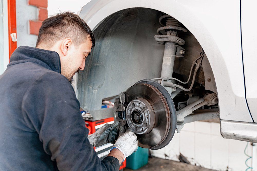 Mechanic Checking The Car Brake — Hagerstown, MD — Guaranteed Truck & Auto Repair Mechanic Checking The Car Brake — Hagerstown, MD — Guaranteed Truck & Auto Repair