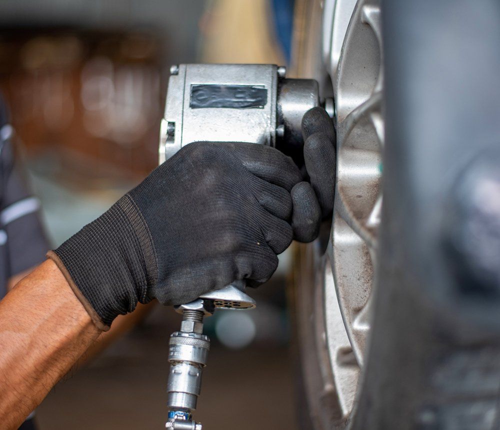 Person Changing Car Tire — Hagerstown, MD — Guaranteed Truck & Auto Repair