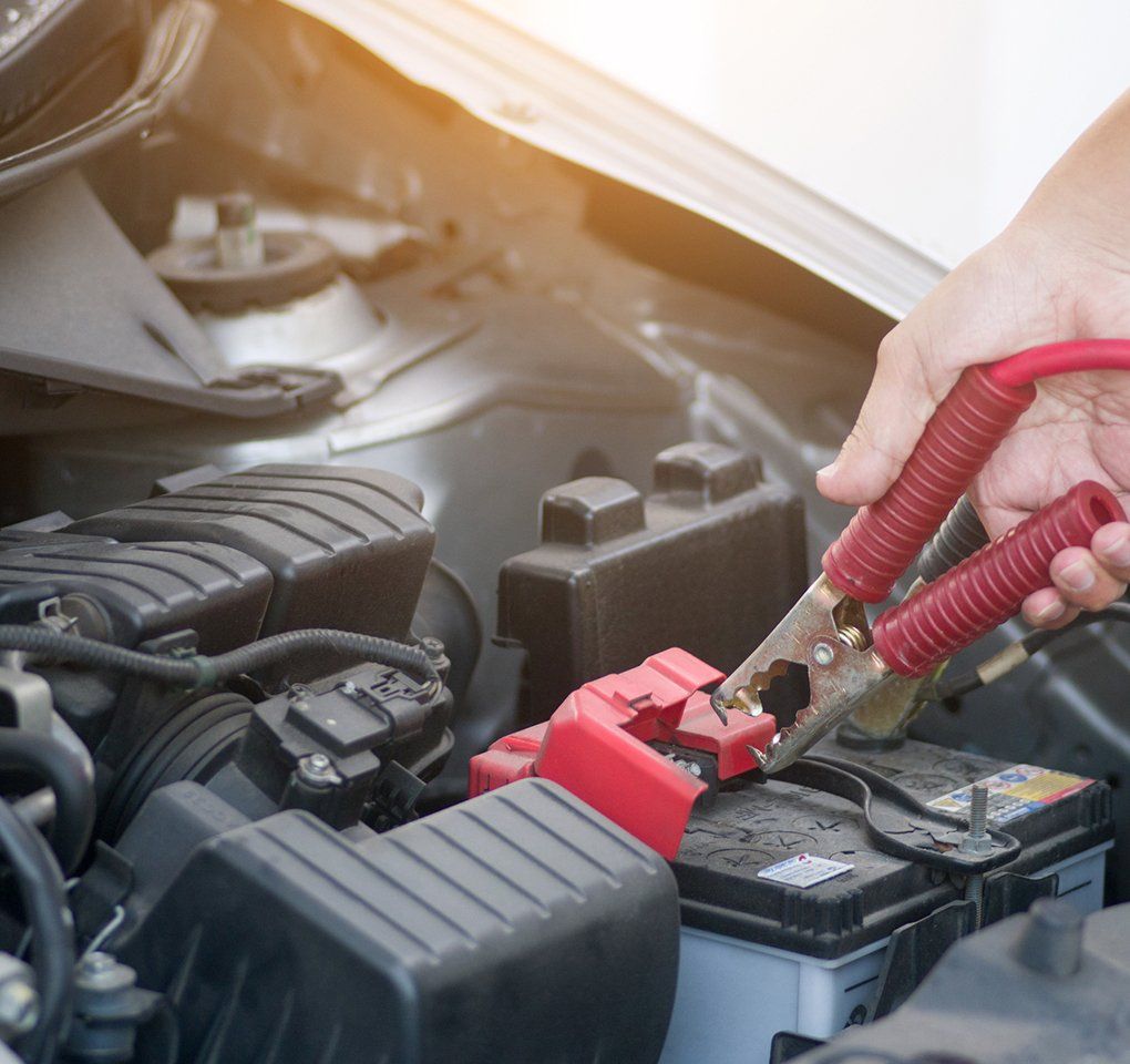 Person Charging Car Battery — Hagerstown, MD — Guaranteed Truck & Auto Repair Person Charging Car Battery — Hagerstown, MD — Guaranteed Truck & Auto Repair
