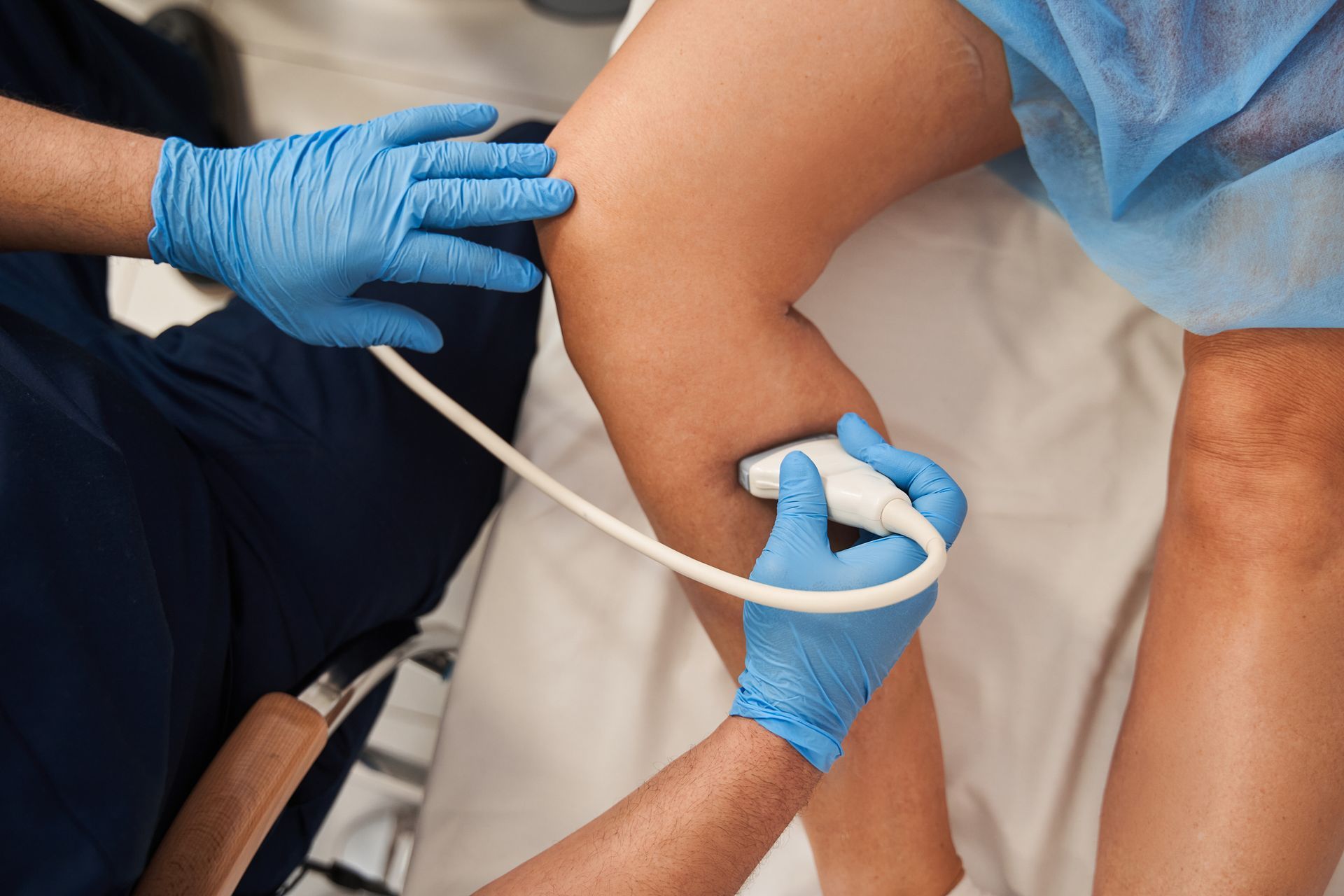 A doctor is examining a patient 's knee with an ultrasound.