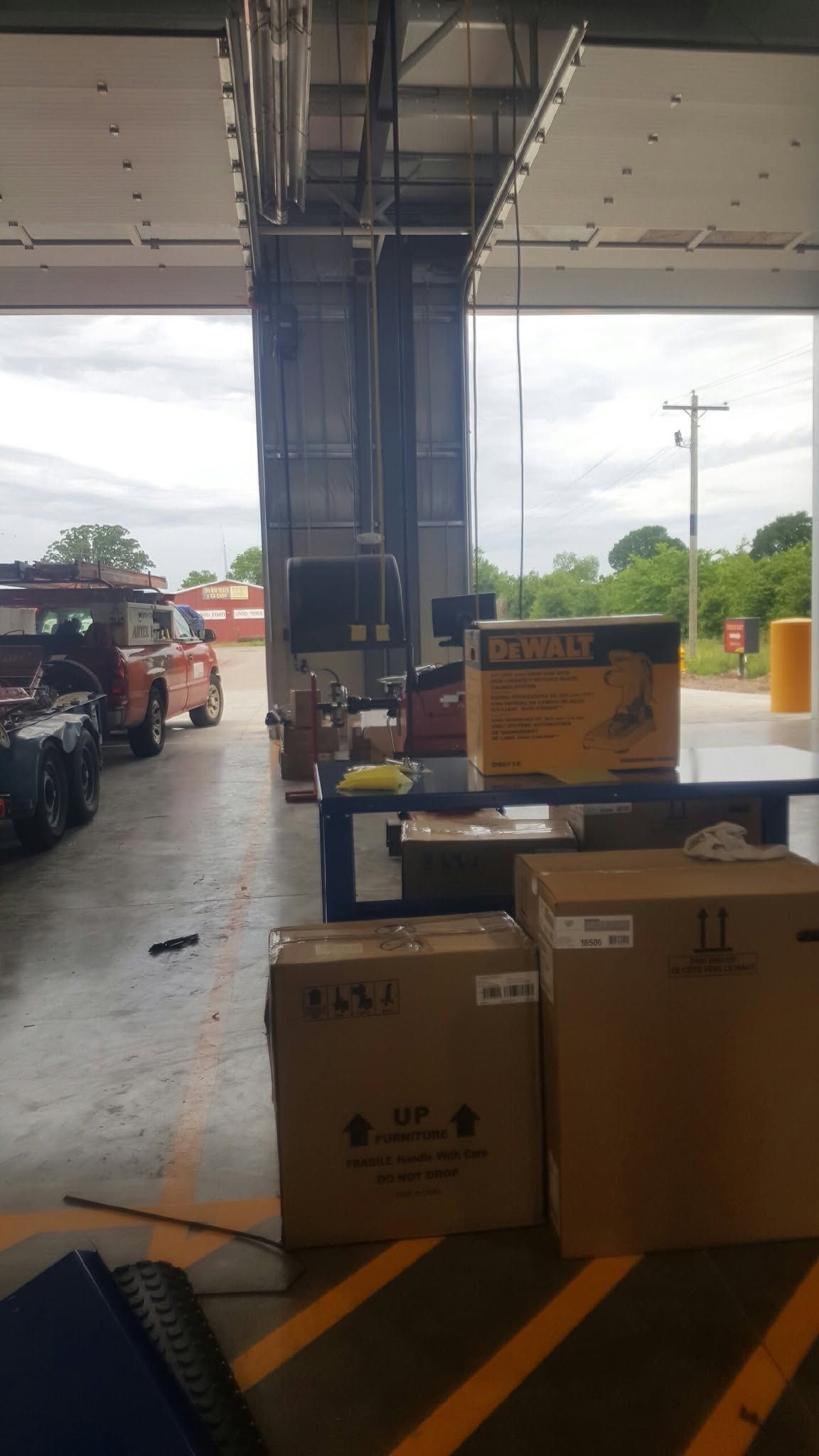 Boxes and a yellow cart near a warehouse loading bay under a covered dock.