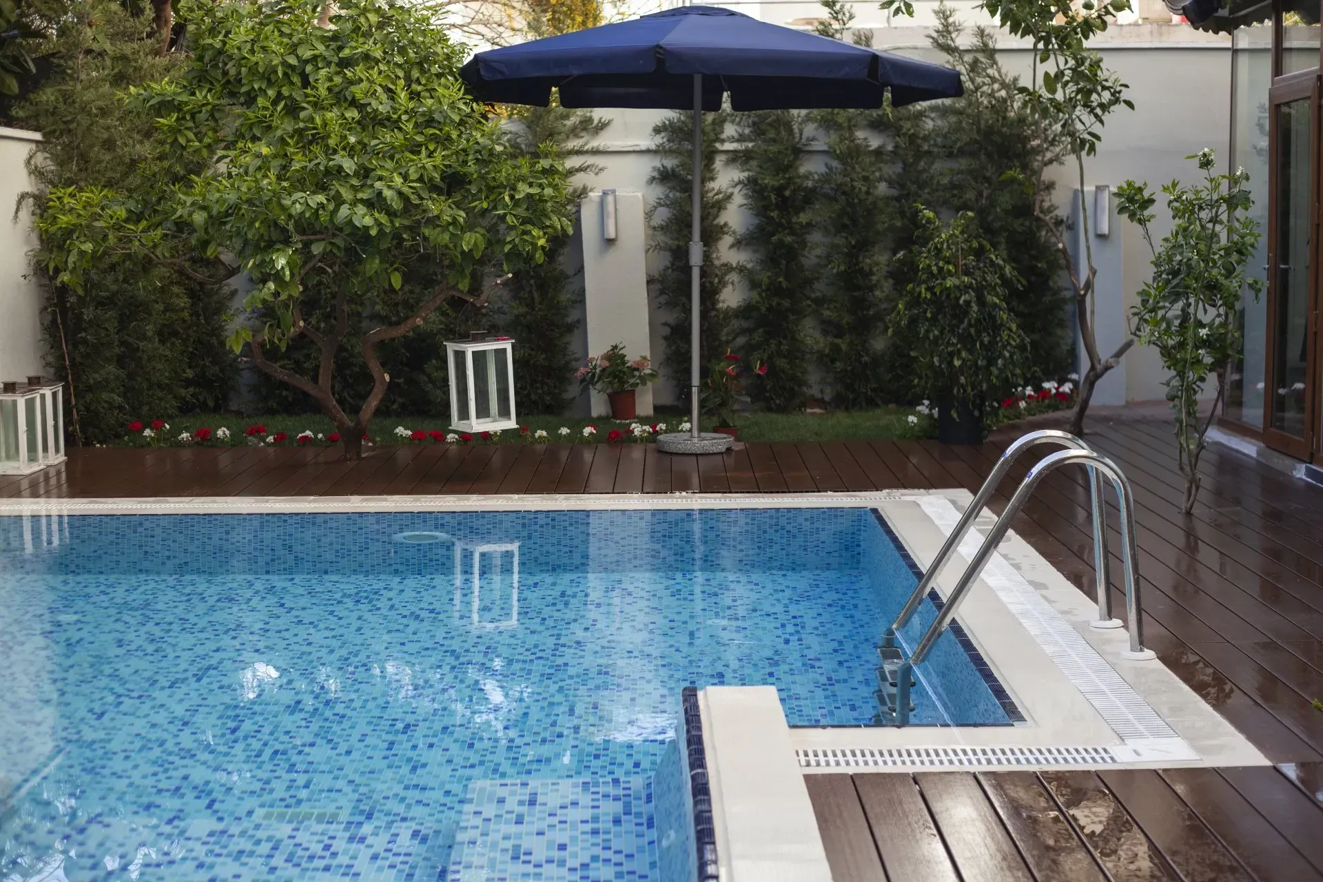 A large swimming pool with a blue umbrella in the background