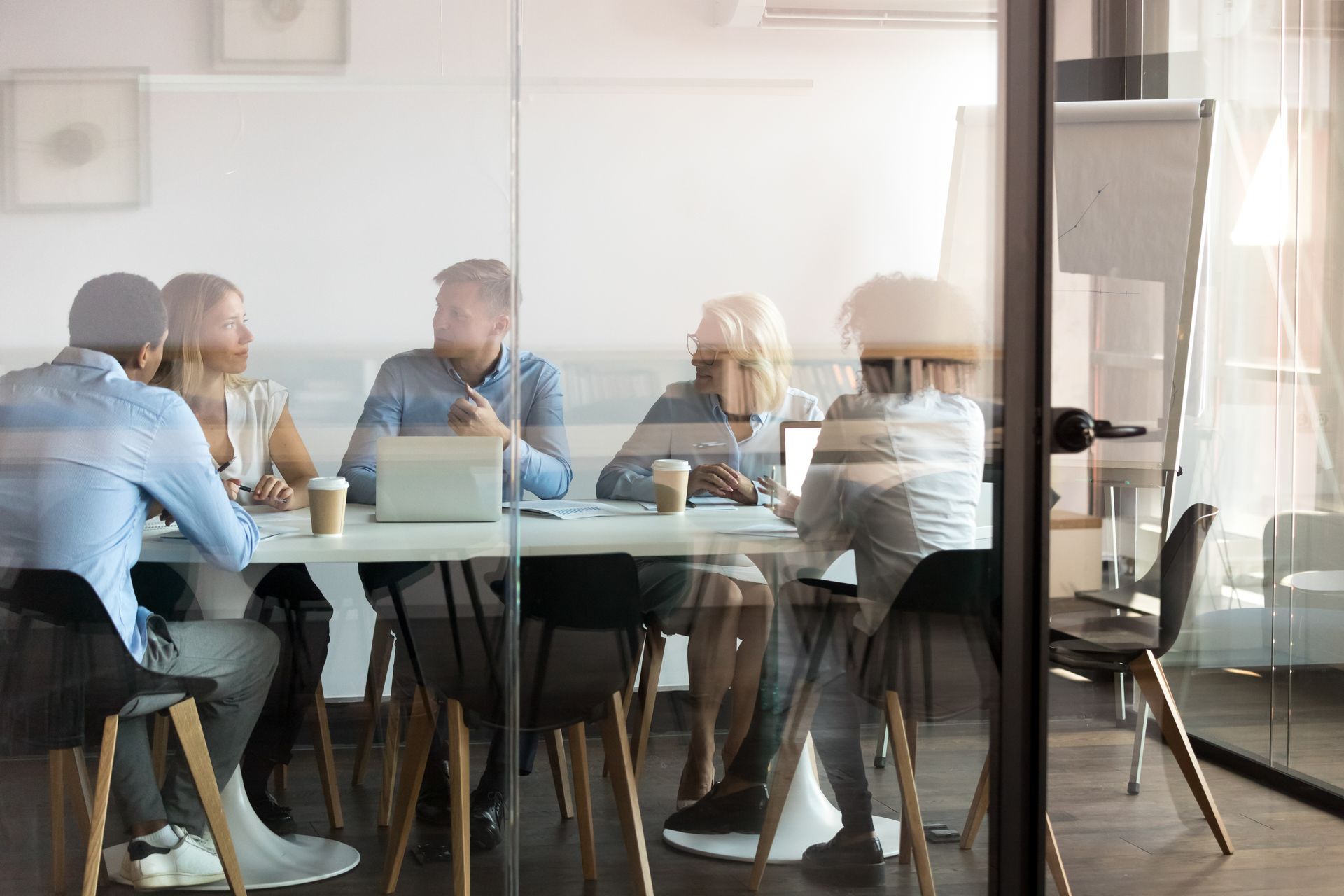 A group of people are sitting around a table in a conference room.