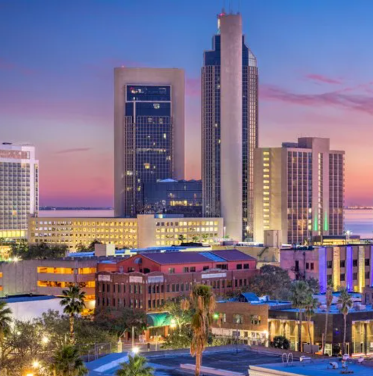 A city skyline at night with a hotel in the foreground