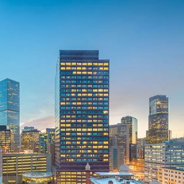 An aerial view of a city skyline at night with a tall building in the foreground.