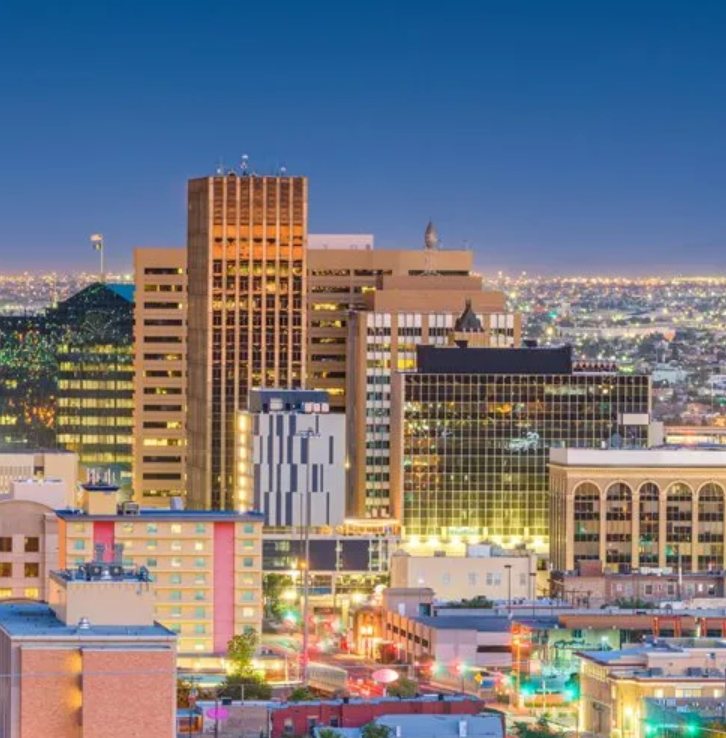An aerial view of a city at night with lots of tall buildings