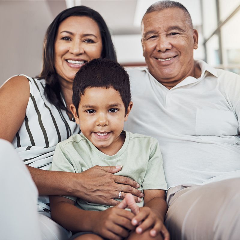 A family is posing for a picture while sitting on a couch.