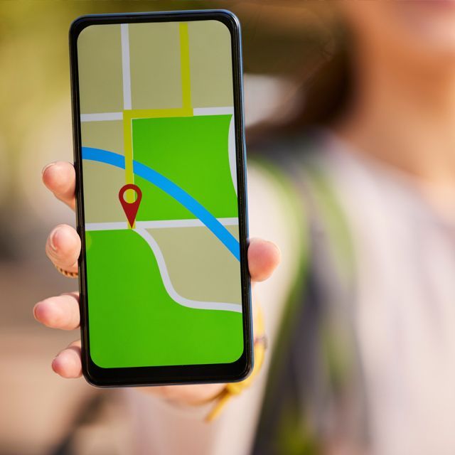 A person is holding a cell phone with a map on it