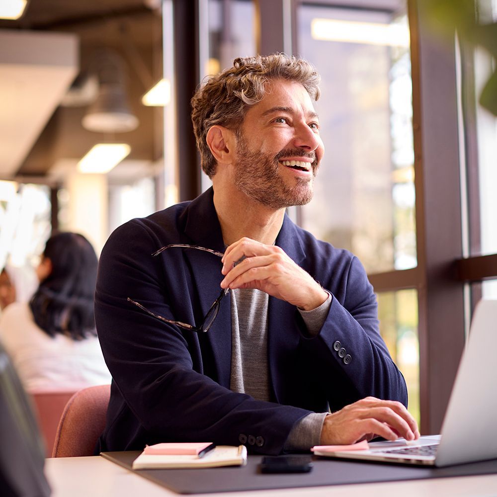 A man is sitting at a desk using a laptop computer.