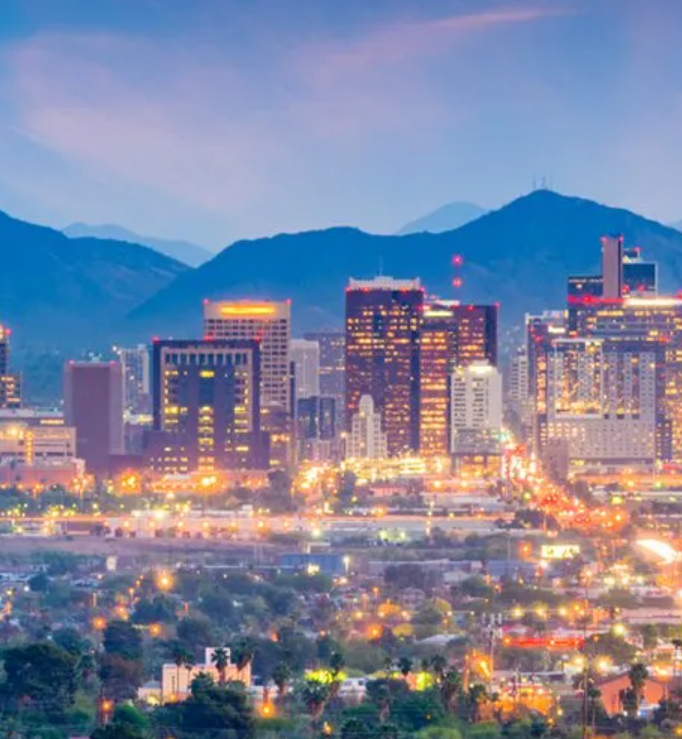 An aerial view of a city at night with mountains in the background.