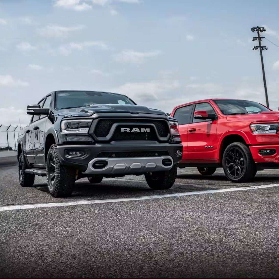 Two ram trucks are parked next to each other in a parking lot.