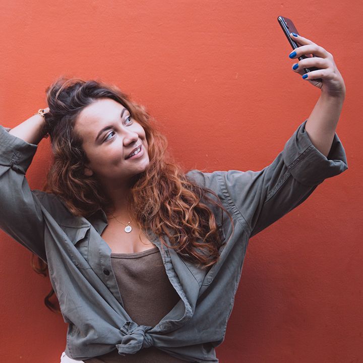 A woman is taking a selfie with her phone.