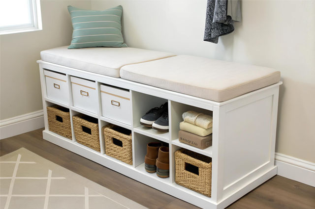 White storage bench with cushioned seat, baskets, and drawers in a bright entryway