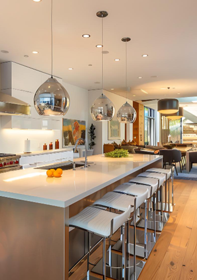 Modern kitchen with large island, bar stools, pendant lights, and a dining area in the background