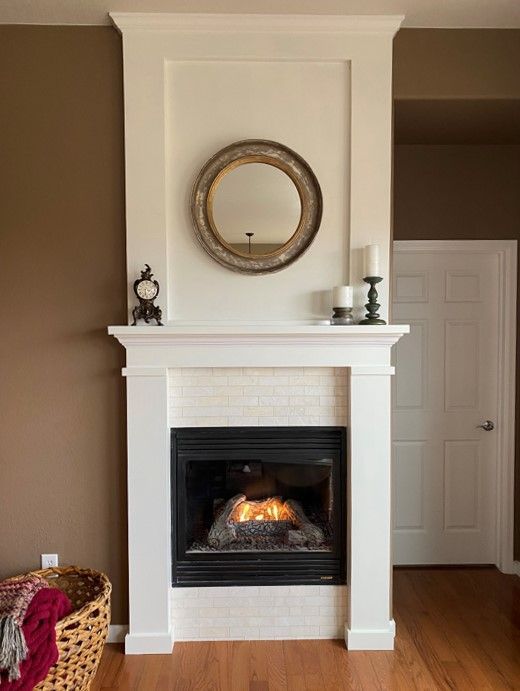 A living room with a fireplace and a mirror on the wall.