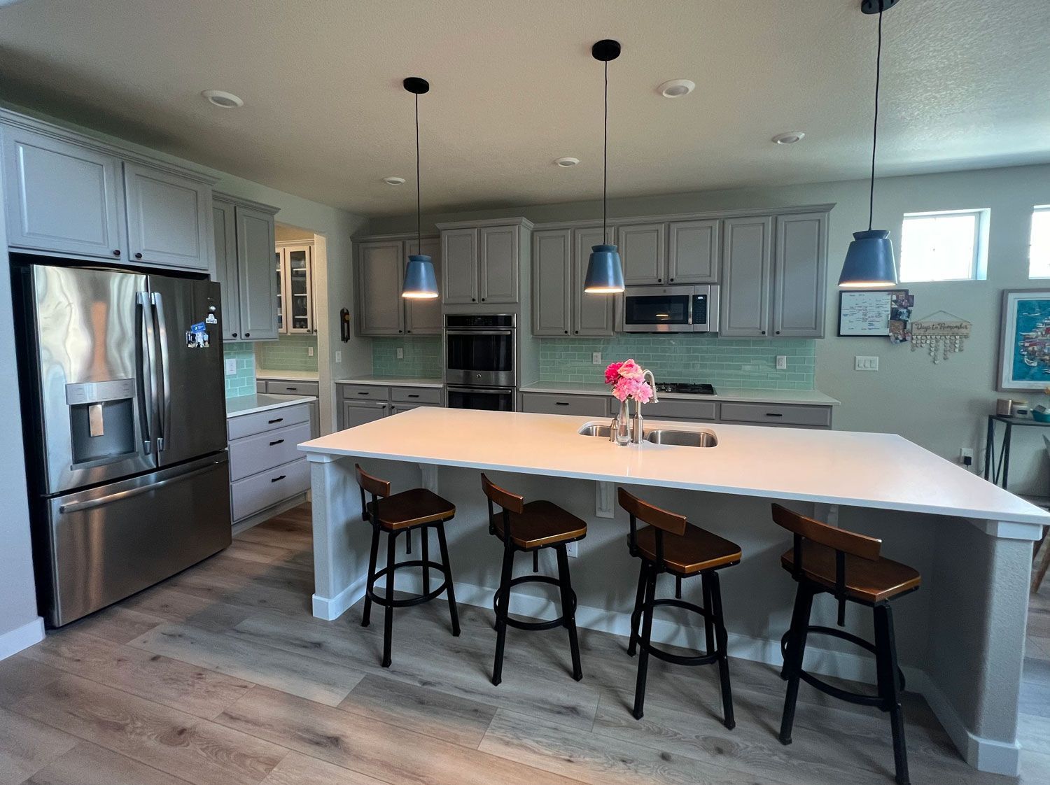 There is a large island in the middle of the kitchen with stools.