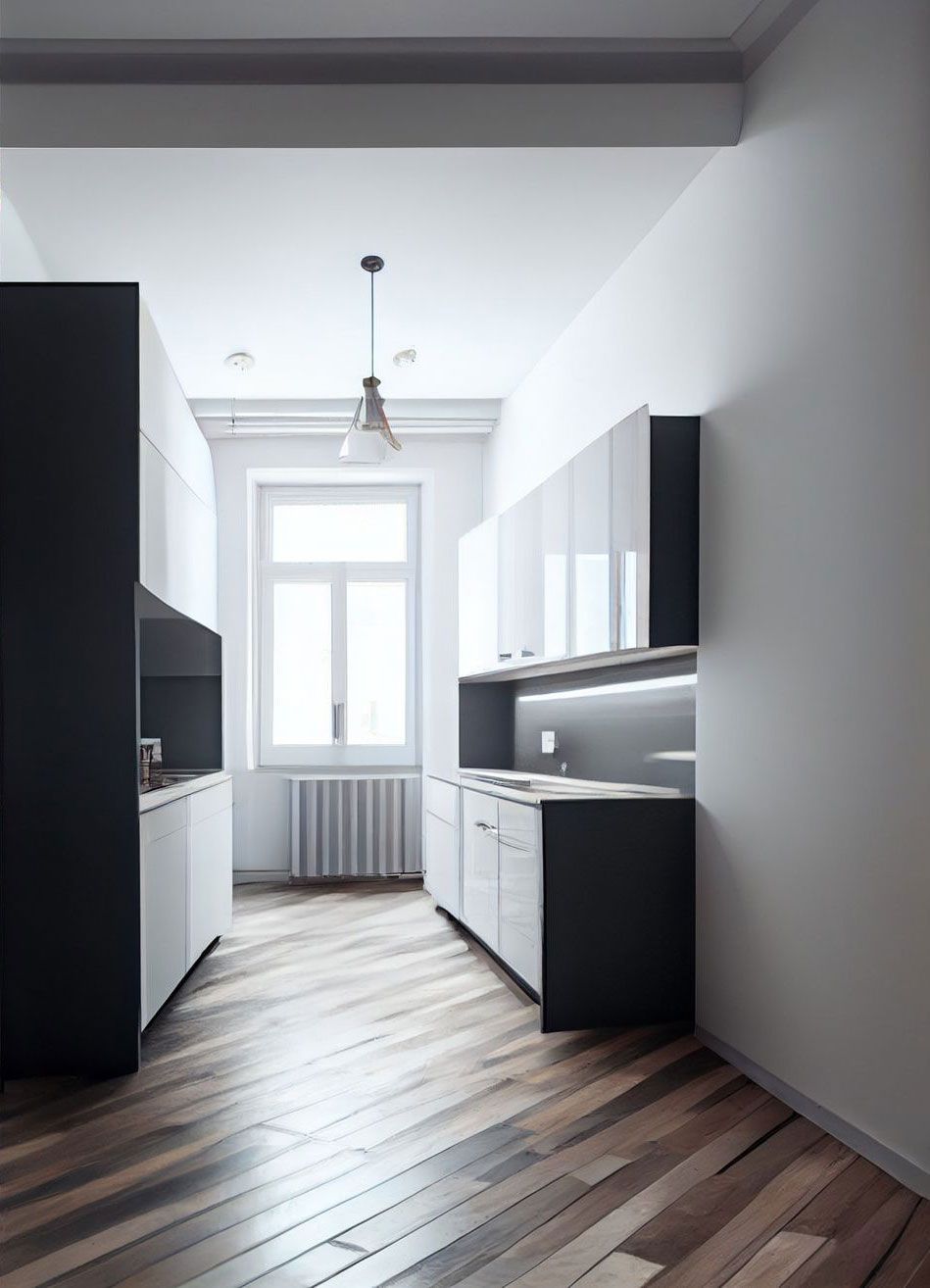A kitchen with black and white cabinets and wooden floors.