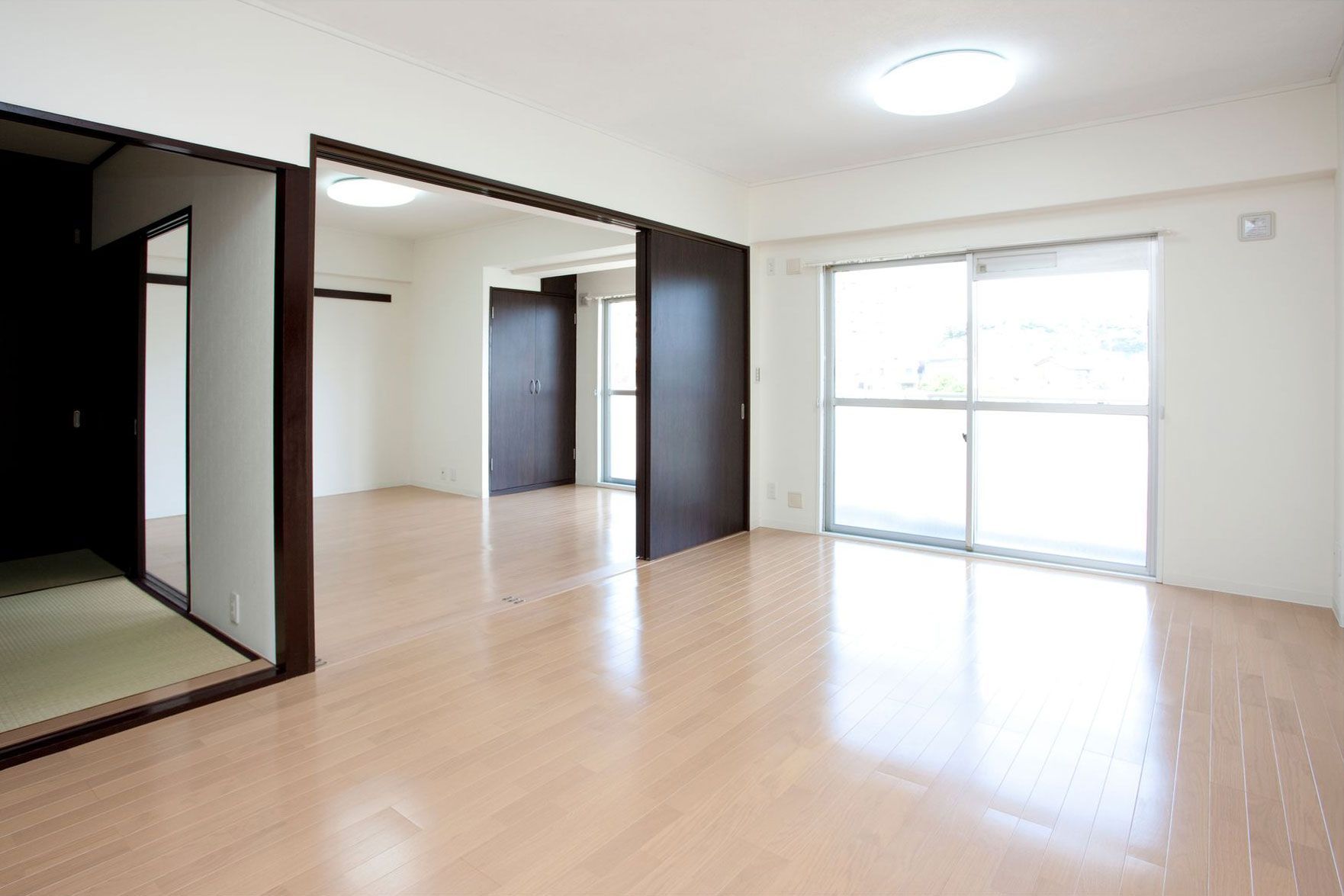 An empty living room with hardwood floors and sliding doors